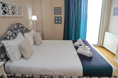 a bedroom with a large white bed with pillows at Best House Kalipso Neo Faliro Piraeus in Piraeus
