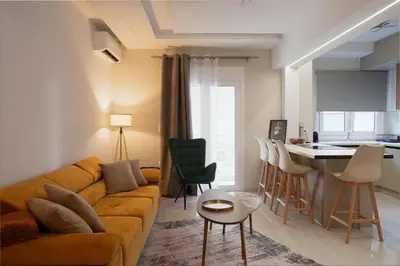 a living room with a couch and a kitchen at Valtinon Smart Corner in Athens