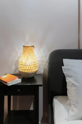 a lamp on a table next to a bed at Athenian Bliss Spotless Nea Smyrni WiFi Studio in Athens