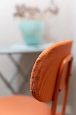 an orange chair with a desk in the background at Athenian Bliss Spotless Nea Smyrni WiFi Studio in Athens