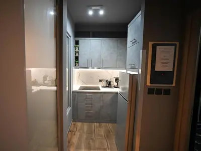 a small kitchen with a sink and a refrigerator at Aiolou 97 Majestic Acropolis View by Zeus Suites in Athens