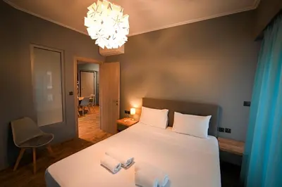 a bedroom with a bed and a chandelier at Aiolou 97 Majestic Acropolis View by Zeus Suites in Athens