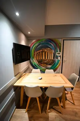 a table and chairs in a room with a painting at Aiolou 97 Majestic Acropolis View by Zeus Suites in Athens