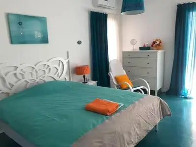 a bedroom with a bed with an orange pillow on it at Sweet Apartment By The Sea in Athens