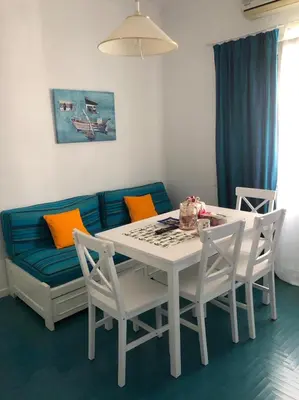 a living room with a table and a couch at Sweet Apartment By The Sea in Athens