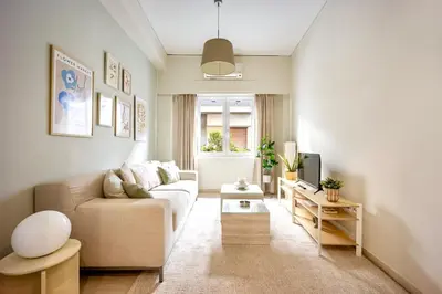 a living room with a couch and a tv at Cozy Home 3 min walk from Ancient Agora in Athens