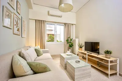 a living room with a couch and a tv at Cozy Home 3 min walk from Ancient Agora in Athens