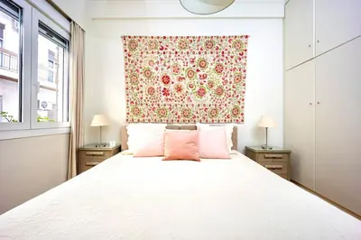 a bedroom with a large white bed with pink pillows at Cozy Home 3 min walk from Ancient Agora in Athens