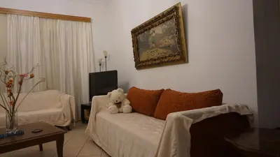a teddy bear sitting on a bed in a living room at George Luxury Apartments in Athens