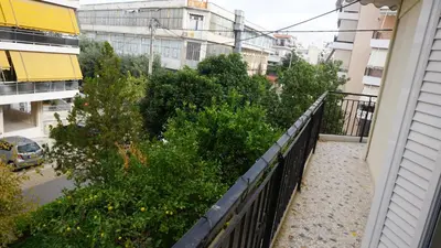 a balcony with a fence and trees and buildings at George Luxury Apartments in Athens