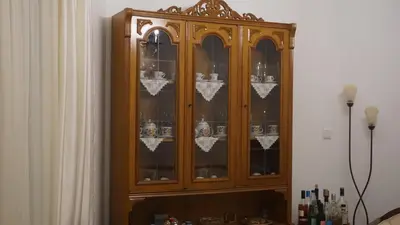 a large wooden cabinet with glass doors at George Luxury Apartments in Athens