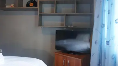 a bedroom with a tv on a wooden stand with a bed at George Luxury Apartments in Athens