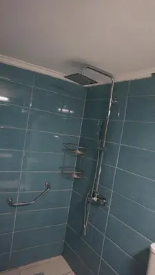 a bathroom with a shower with blue tiles at George Luxury Apartments in Athens