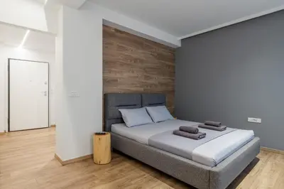 a bedroom with a bed with a wooden wall at New Korinis 3 Athens studio in Athens