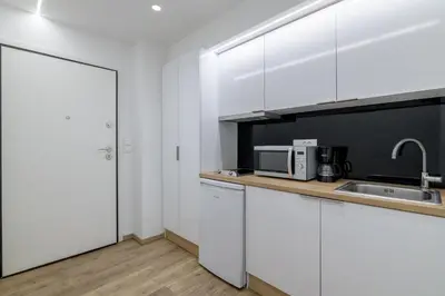 a kitchen with white cabinets and a sink and a door at New Korinis 3 Athens studio in Athens