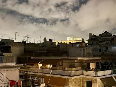 a city skyline with buildings and a cloudy sky at Luxury Retreat with Iconic Acropolis View Koukaki in Athens