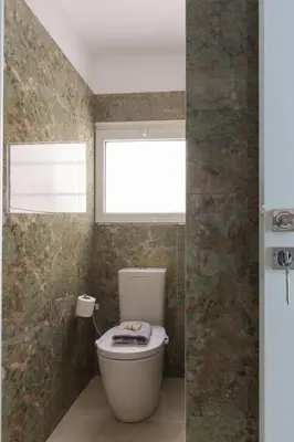 a bathroom with a toilet and a window at Luxury Retreat with Iconic Acropolis View Koukaki in Athens