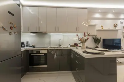 a kitchen with white cabinets and a counter top at varkiza luxury 2BD apartment in Vari