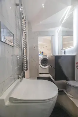 a bathroom with a toilet and a washing machine at varkiza luxury 2BD apartment in Vari