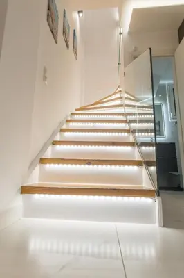 a staircase in a house with white walls and wooden steps at varkiza luxury 2BD apartment in Vari