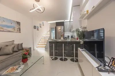 a living room with a couch and a kitchen at varkiza luxury 2BD apartment in Vari