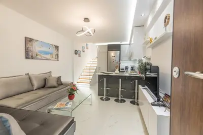 a large living room with a couch and a kitchen at varkiza luxury 2BD apartment in Vari