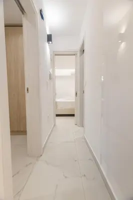 a hallway with white walls and a white tile floor at varkiza luxury 2BD apartment in Vari