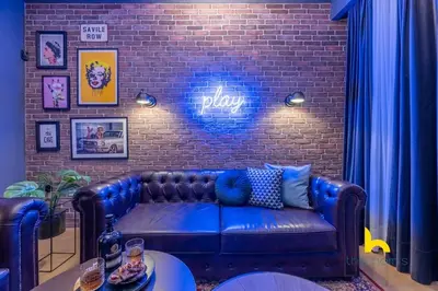 a living room with a blue couch against a brick wall at Unique Urban Cave w Pool Table Near Acropolis! in Athens