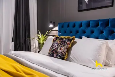 a bed with a blue headboard and white pillows at Unique Urban Cave w Pool Table Near Acropolis! in Athens