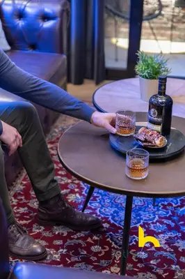a person reaching for a plate of food and a bottle of wine at Unique Urban Cave w Pool Table Near Acropolis! in Athens