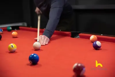 a person playing pool with a cue on a pool table at Unique Urban Cave w Pool Table Near Acropolis! in Athens