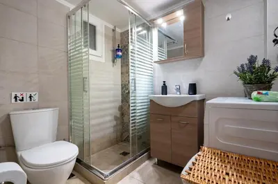 a bathroom with a shower and a toilet and a sink at Steps from the Heart of Zografou- 3 Guests by ΜΡS in Athens