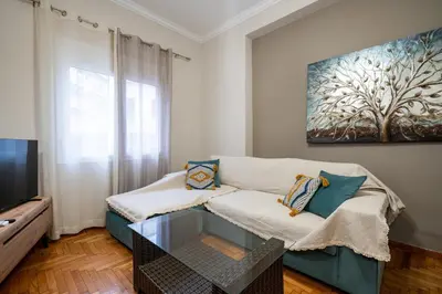 a living room with a couch and a tv at Steps from the Heart of Zografou- 3 Guests by ΜΡS in Athens