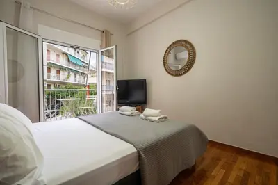 a bedroom with a bed and a mirror and a window at Steps from the Heart of Zografou- 3 Guests by ΜΡS in Athens