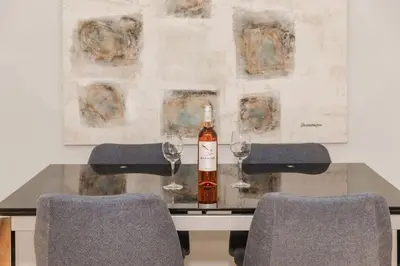a bottle of wine sitting on a table with two glasses at Acropolis experience apartment! in Athens