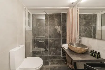 a bathroom with a sink and a toilet and a shower at Acropolis experience apartment! in Athens