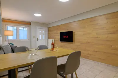 a dining room with a table and a tv on a wall at Two steps from Acropolis in Athens