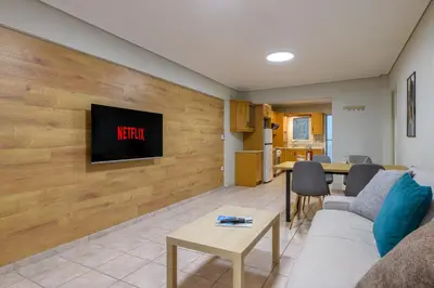 a living room with a couch and a tv on a wall at Two steps from Acropolis in Athens