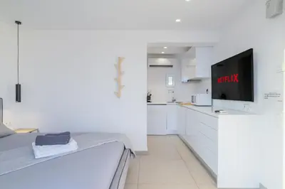 a white kitchen with a tv on a counter at Jacuzzi Penthouse with sea view 5th floor in Athens