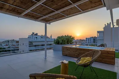 a rooftop patio with a hot tub and chairs at Jacuzzi Penthouse with sea view 5th floor in Athens