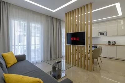 a living room with a couch and a table and a kitchen at Brand new 3bedrooms apartment in Athens
