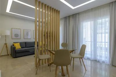 a living room with a table and chairs and a couch at Brand new 3bedrooms apartment in Athens