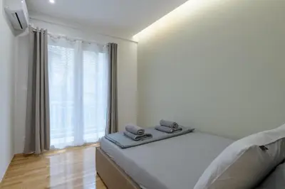 a bedroom with a bed and a large window at Brand new 3bedrooms apartment in Athens