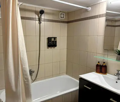 a bathroom with a shower and a tub and a sink at Amalia cosy home in Athens