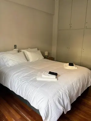 a bedroom with a white bed with towels on it at Amalia cosy home in Athens