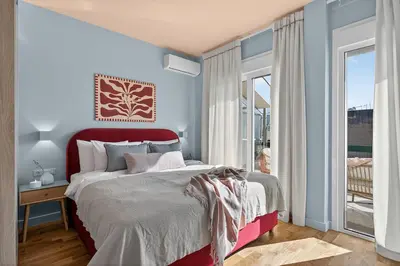 a bedroom with a large bed with a red headboard at Fireside Kallithea - Large Veranda I -2BR by ΜΡS in Athens