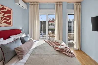 a bedroom with a bed with a red head board at Fireside Kallithea - Large Veranda I -2BR by ΜΡS in Athens