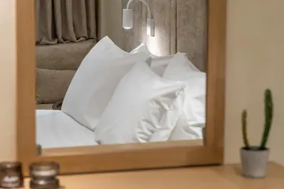 a mirror reflecting a pile of white pillows at Athensis Central Suites in Athens