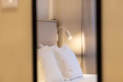 a mirror reflection of a bed with a pillow at Athensis Central Suites in Athens