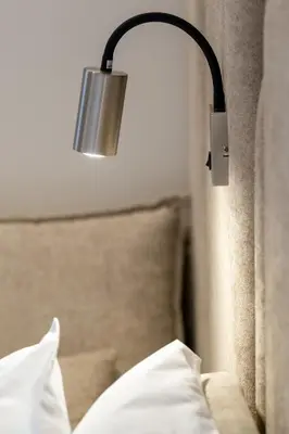 a lamp hanging on a wall next to a bed at Athensis Central Suites in Athens